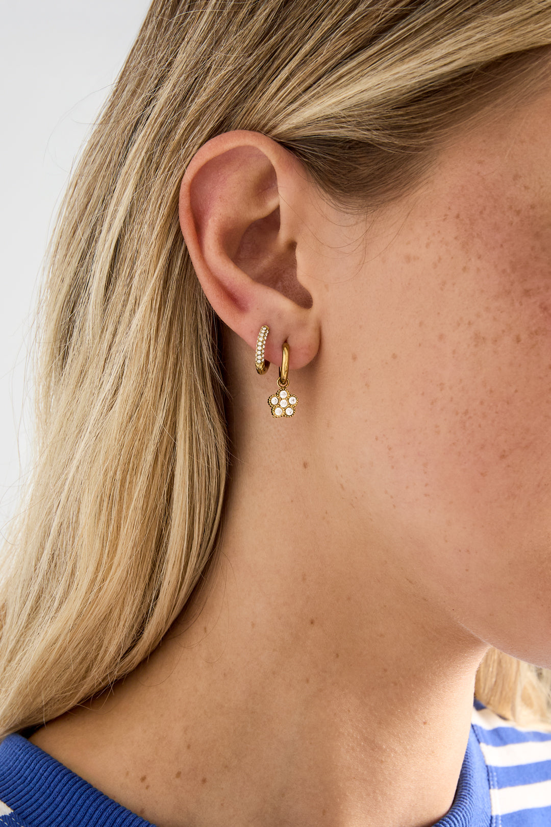 Small hoop earrings with hanging flowers made of zirconia stones